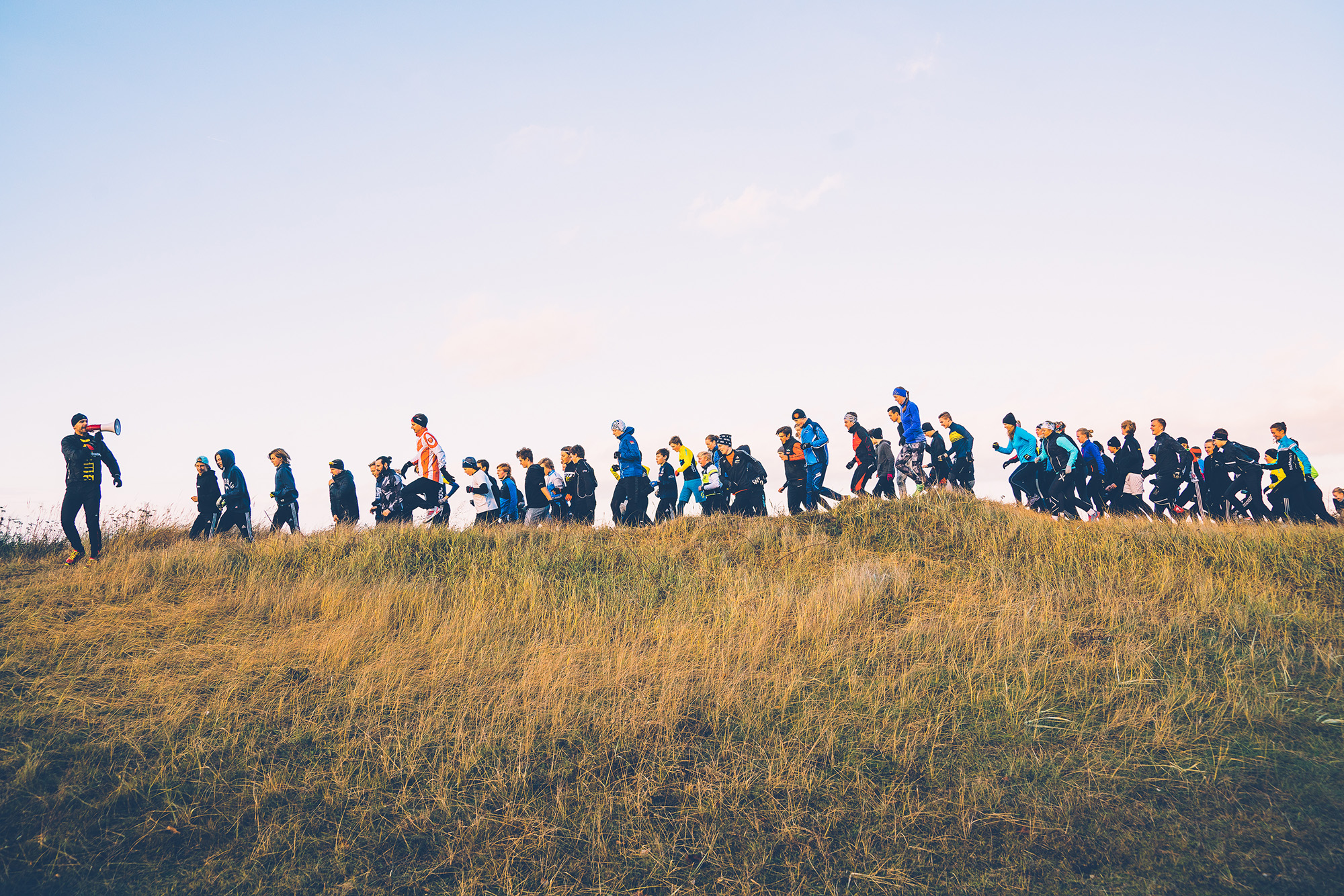 Fredrik Sträng coachar individer under en gruppträning på en strand